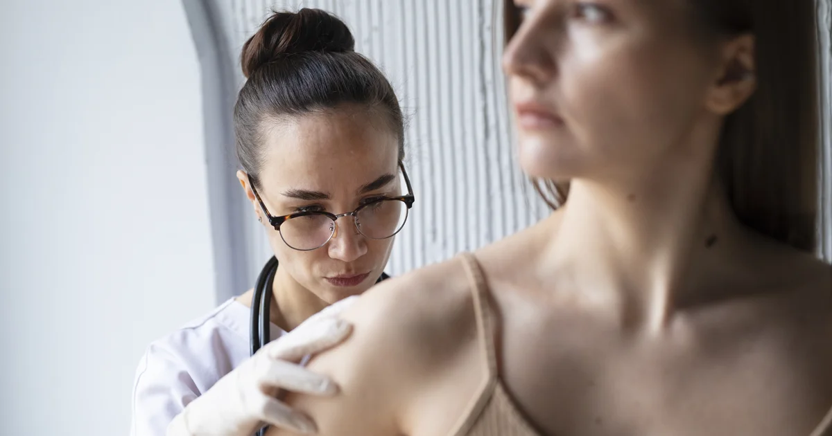 Dermatovenerologička podrobne diagnostikuje nebezpečné znamienko na koži pacientky v klinike Dermarevolta