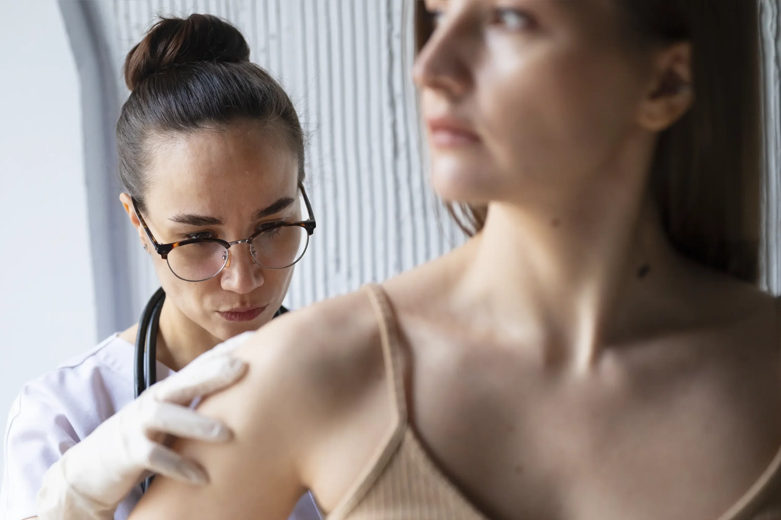 Dermatovenerologička podrobne diagnostikuje nebezpečné znamienko na koži pacientky v klinike Dermarevolta